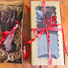 Load image into Gallery viewer, Two gift boxes with red ribbons on a wooden surface
