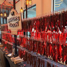 Load image into Gallery viewer, Baker&#39;s Bacon display with hanging bacon in a store setting
